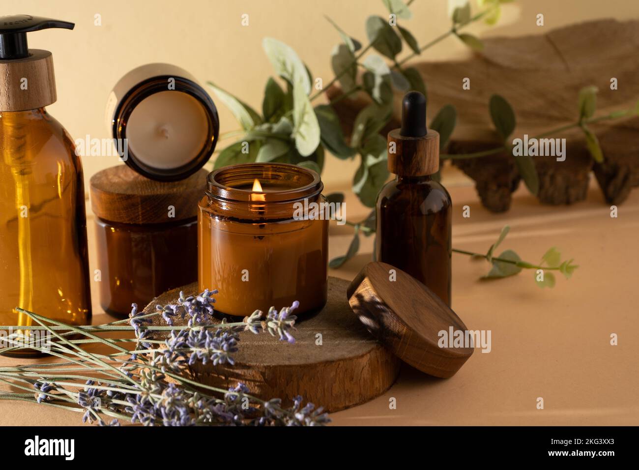 Sojalkerzen in einem Glas. Aromatherapie. Brennende Kerze und Lavendel. Deckel aus Holz für Gläser. Beigefarbener Hintergrund. Komfort und Entspannung. Handgefertigt. Inneneinrichtung. Stockfoto