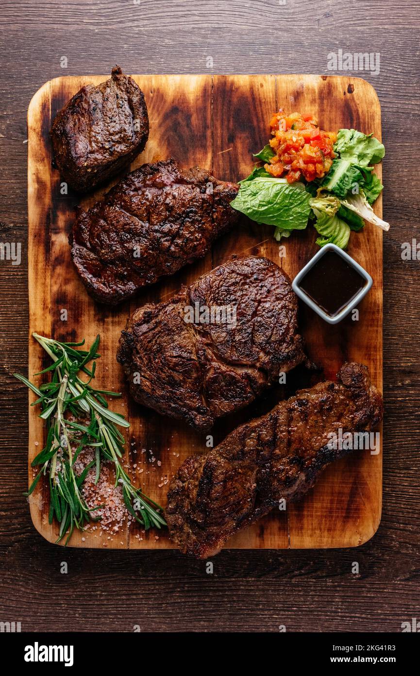 4 verschiedene Steaks auf einem Holzbrett Stockfoto