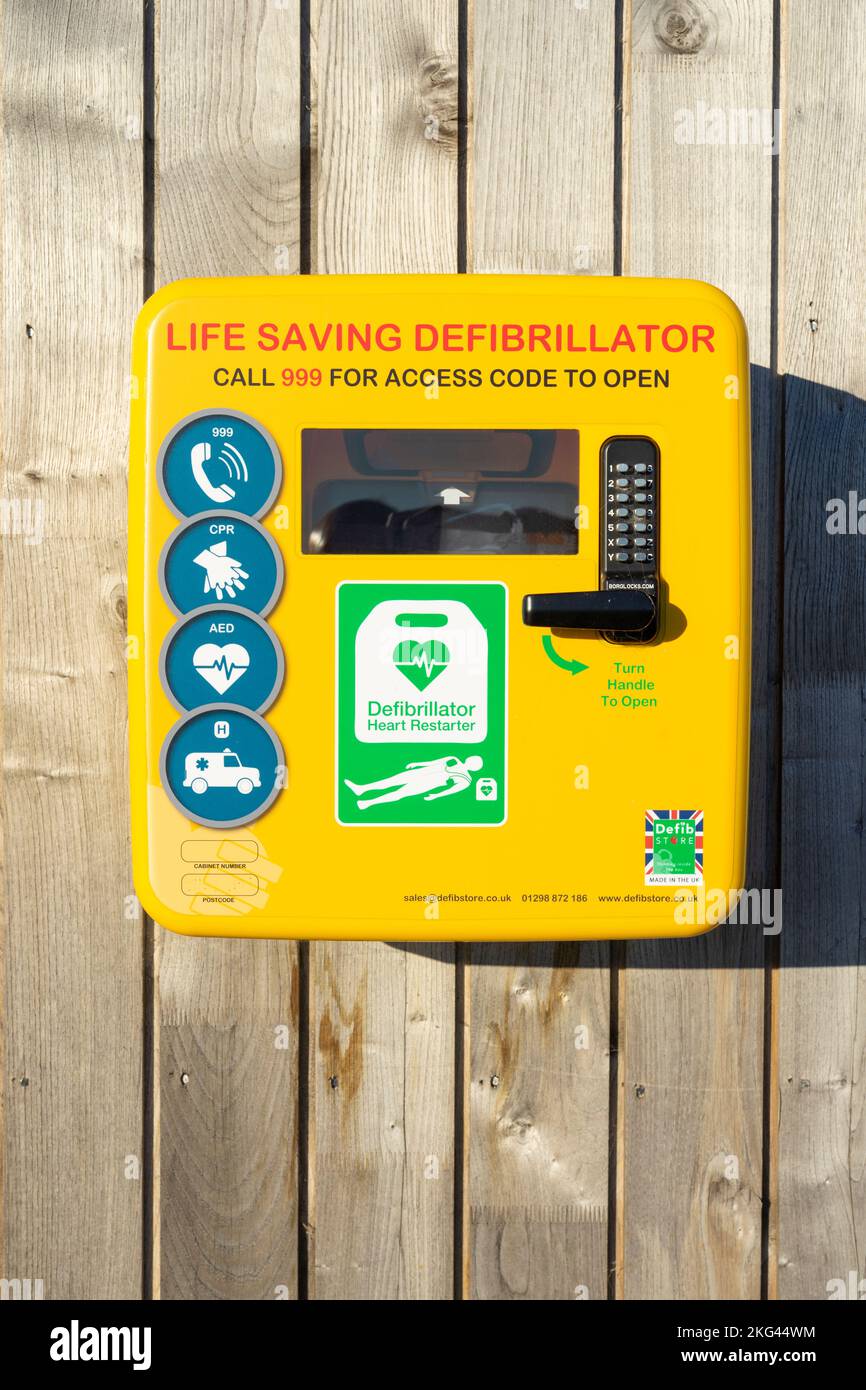 Defibrillator Notfall lebensrettende Ausrüstung Großbritannien Defibrillator in einem gelben, sicheren Gehäuse an einer Wand für den Notfall nur England GB Europa Stockfoto