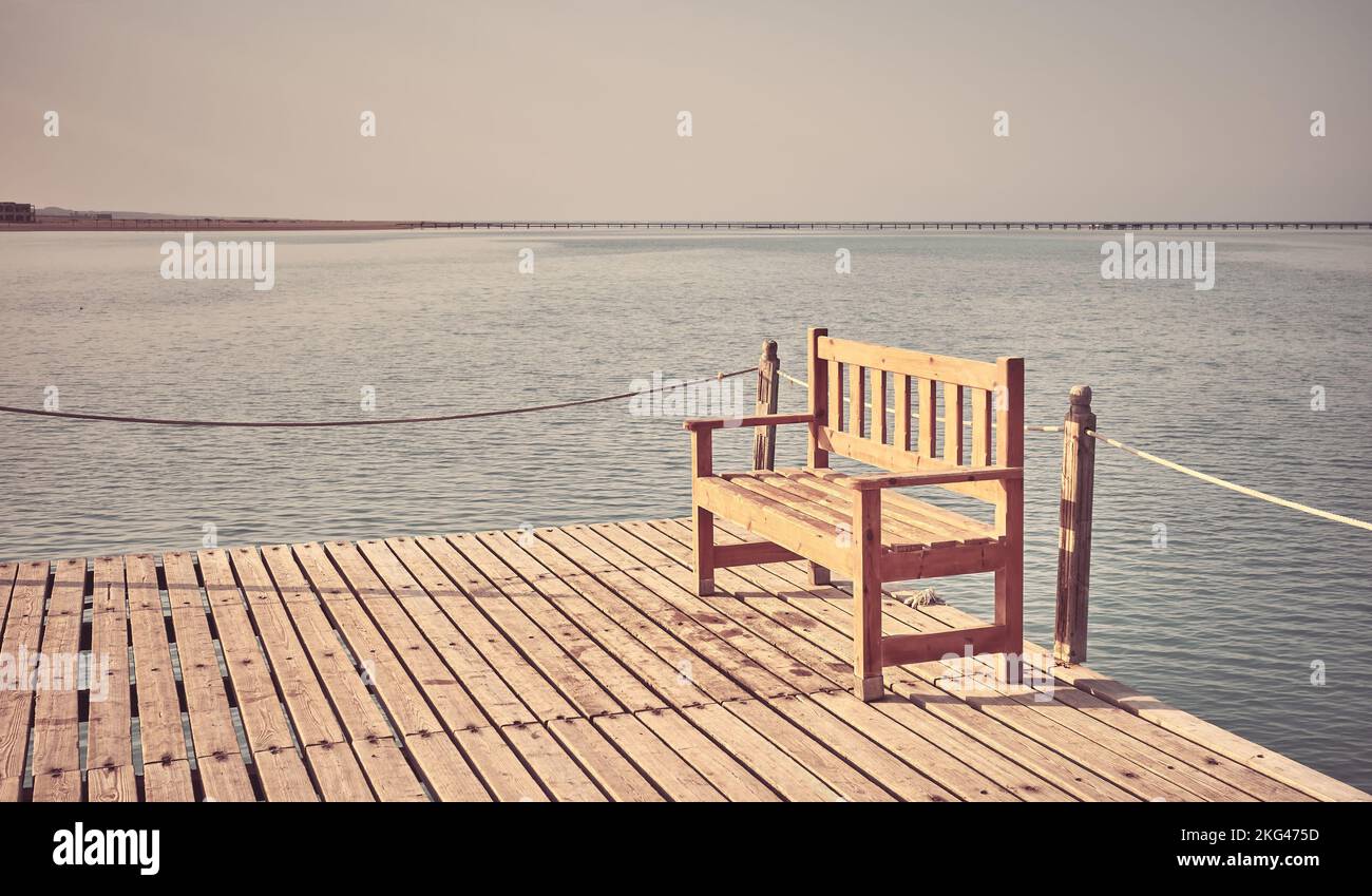 Holzbank an einem Pier, Retro-Stil Tonung angewendet. Stockfoto