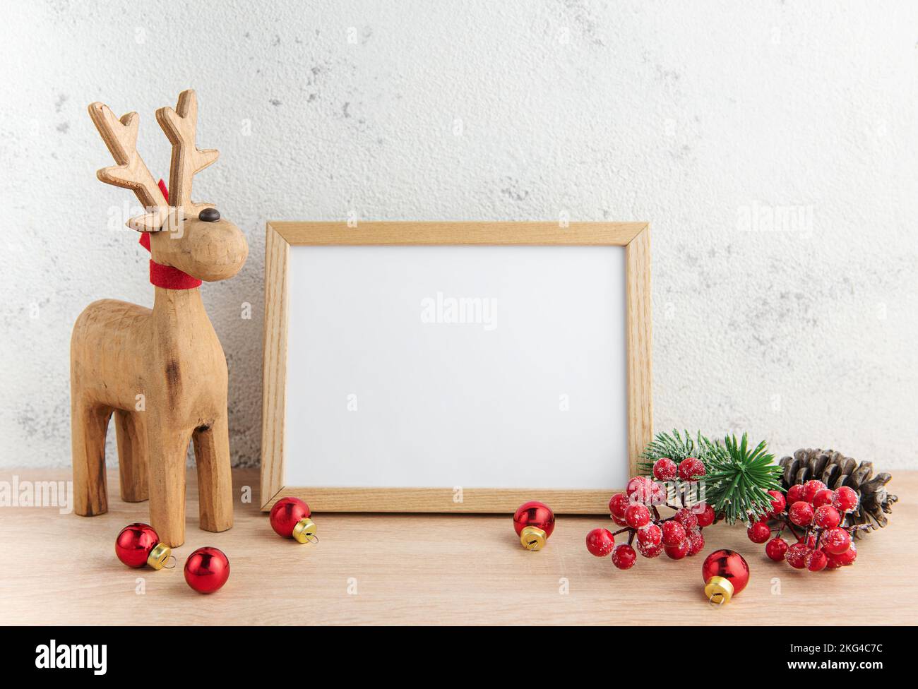 Weißer leerer Holzrahmen-Nachbau mit Weihnachtsdekorationen auf dem Holztisch. Rahmen für Anführungszeichen. Weihnachtspostkarte. Stockfoto