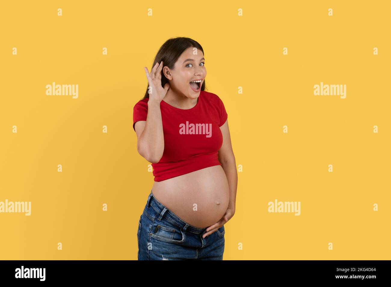 Klatsch-Konzept. Eine neugierige schwangere Frau hält die Hand nahe am Ohr, um Nachrichten zu hören Stockfoto