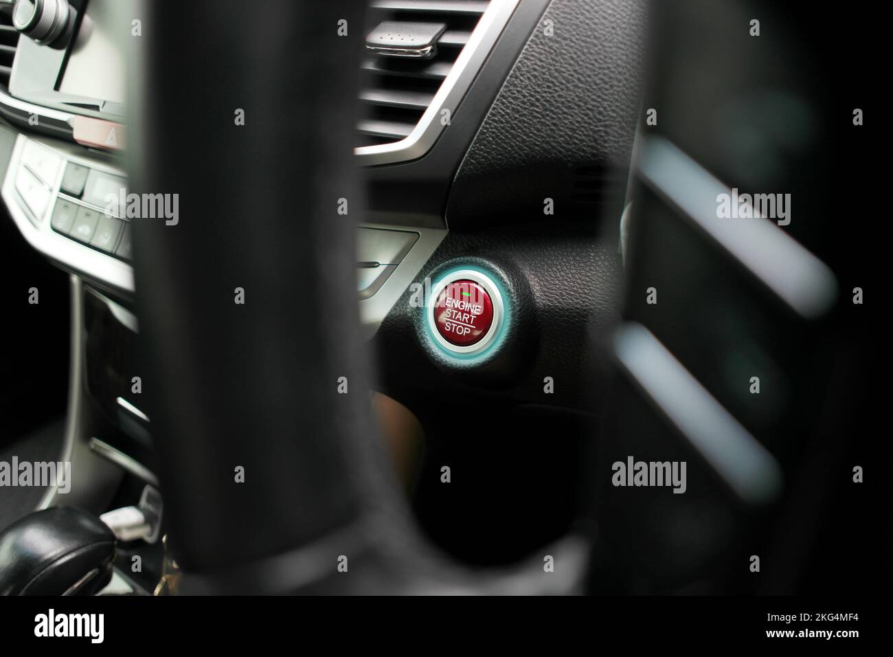 Roter Motor-Start-Stopp-Knopf mit blauer LED auf dem Bedienfeld eines Fahrzeugs Stockfoto