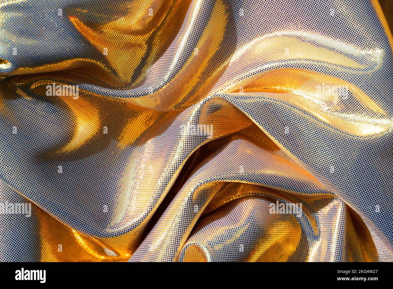 Ein gewellter goldfarbener Stoffhintergrund. Stockfoto