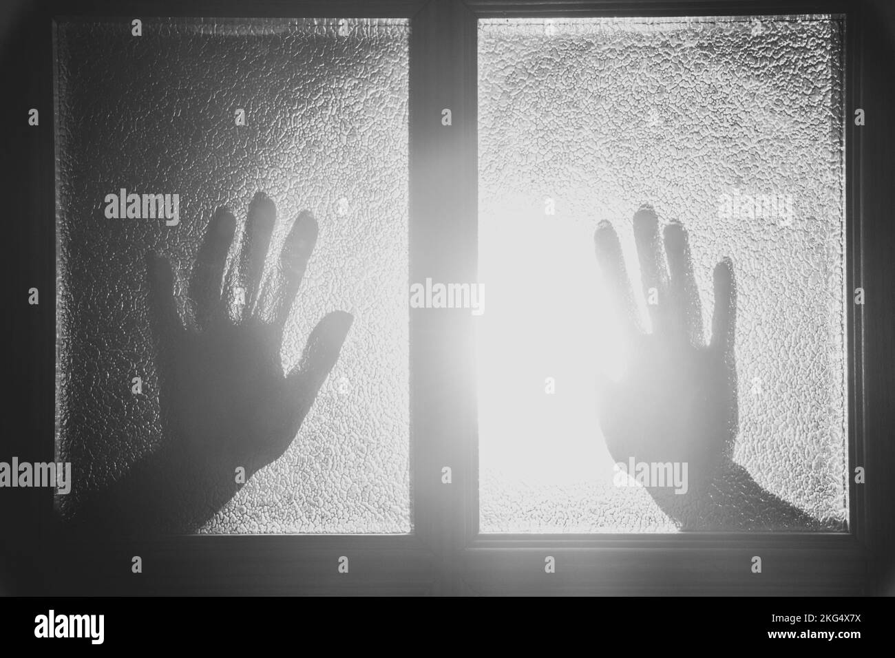 Hände an die Glastür im Haus im Dunkeln wie ein Schatten, Angst, Hilfe, Gewalt Stockfoto