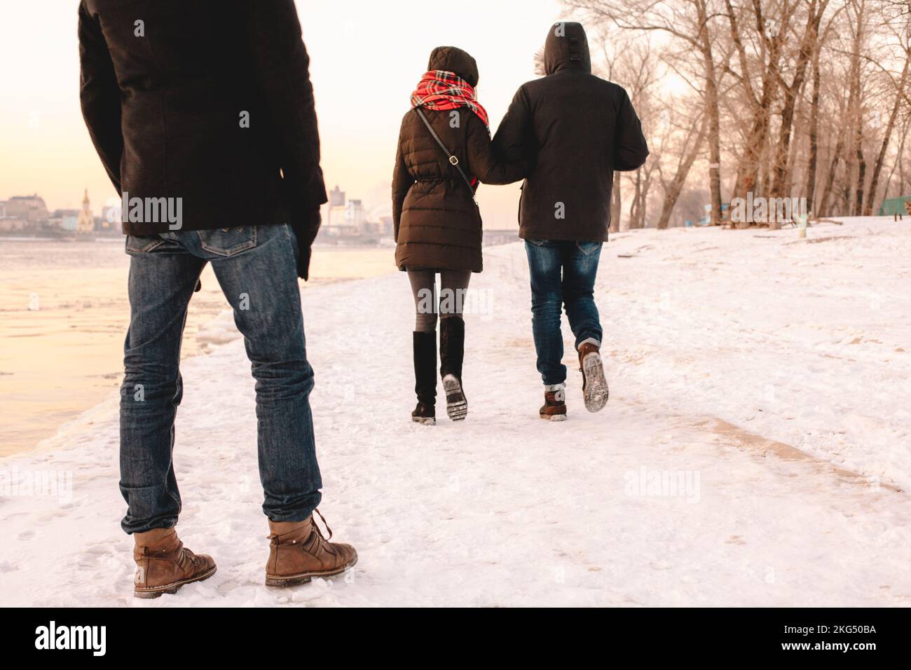 Rückansicht eines jungen Mannes, der im Winter ein Paar auf dem Fluss zu Fuß sieht Stockfoto