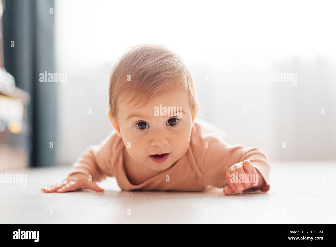 Ein kleines Kind krabbelt auf den Boden. Kind im Alter von 6 Monaten. Stockfoto