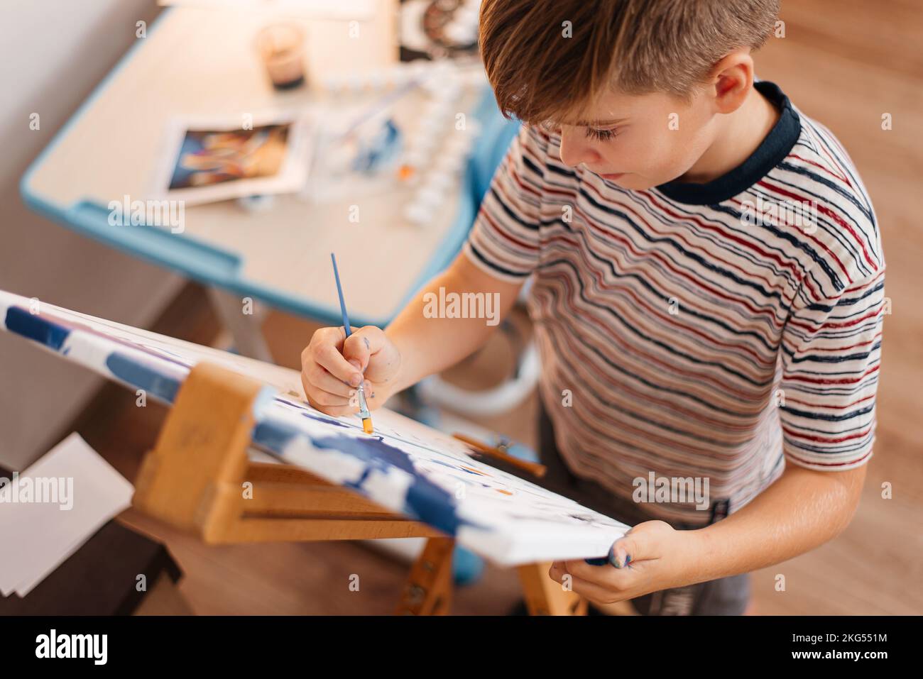 Der Junge zeichnet ein Bild nach den Zahlen. Stockfoto