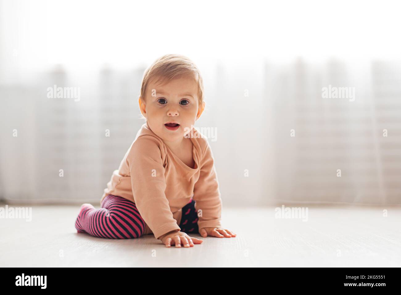 Das kleine Mädchen krabbelt auf dem Boden. Weißer Hintergrund Stockfoto