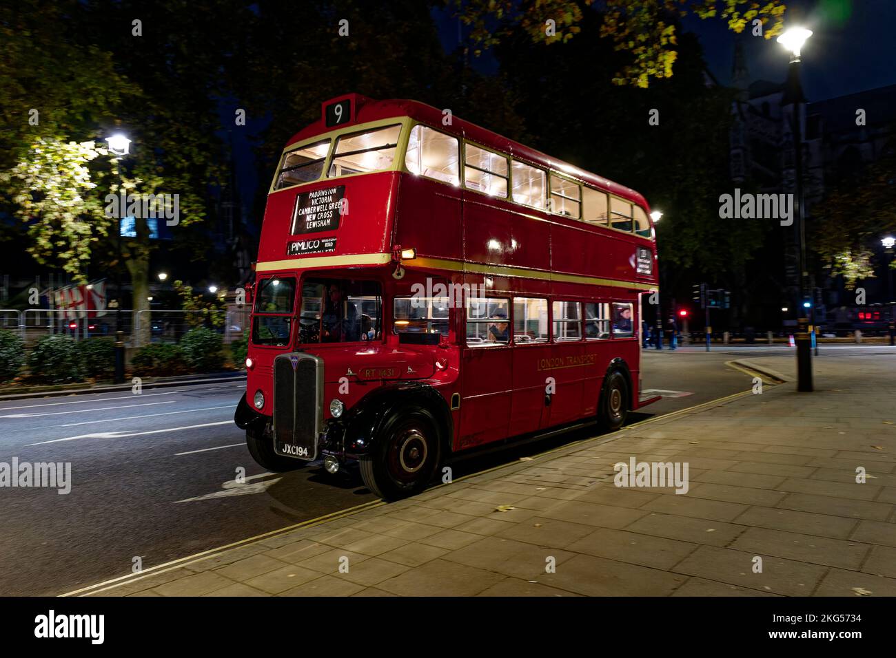 Klassischer roter Londoner Doppeldeckerbus, der nachts am Parliament Square in London geparkt hat Stockfoto