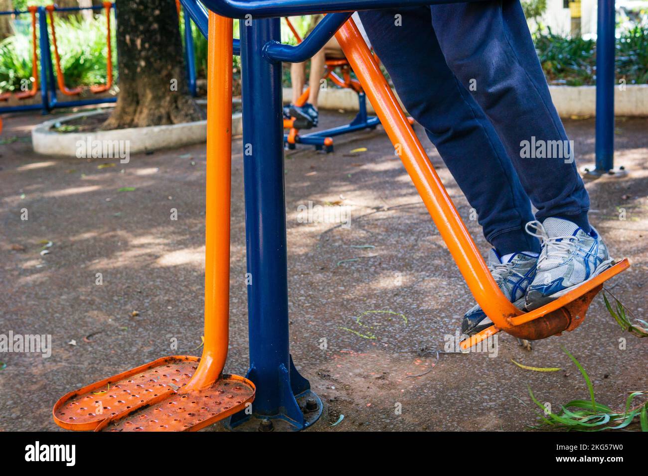 Im Parque Rosinha Cadar in Belo Horizonte, Brasilien, schwingt ein Mann auf einem Outdoor-Fitnessgerät seine Beine. Stockfoto