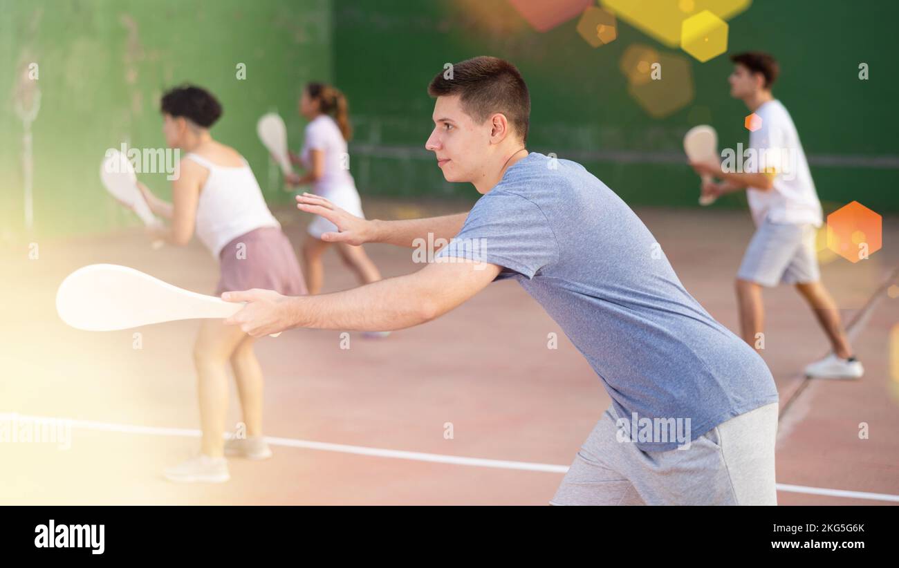 Konzentrierter junger Mann, Paleta-Frontspieler, trifft mit Schläger den Ball Stockfoto