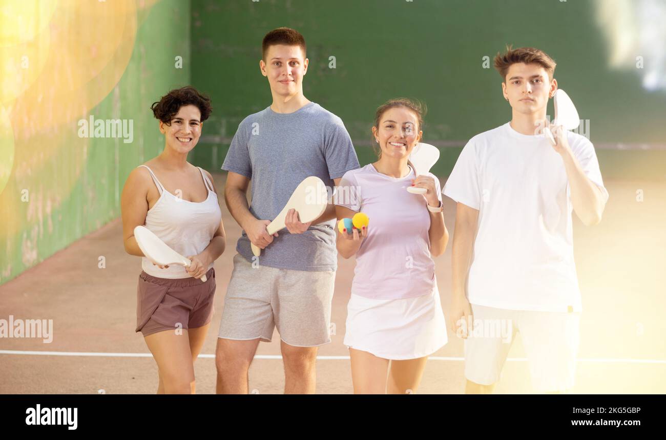 Fröhliche Pelota-Spieler mit hölzernen paletas und Gummibällen im Freien Frontton Stockfoto