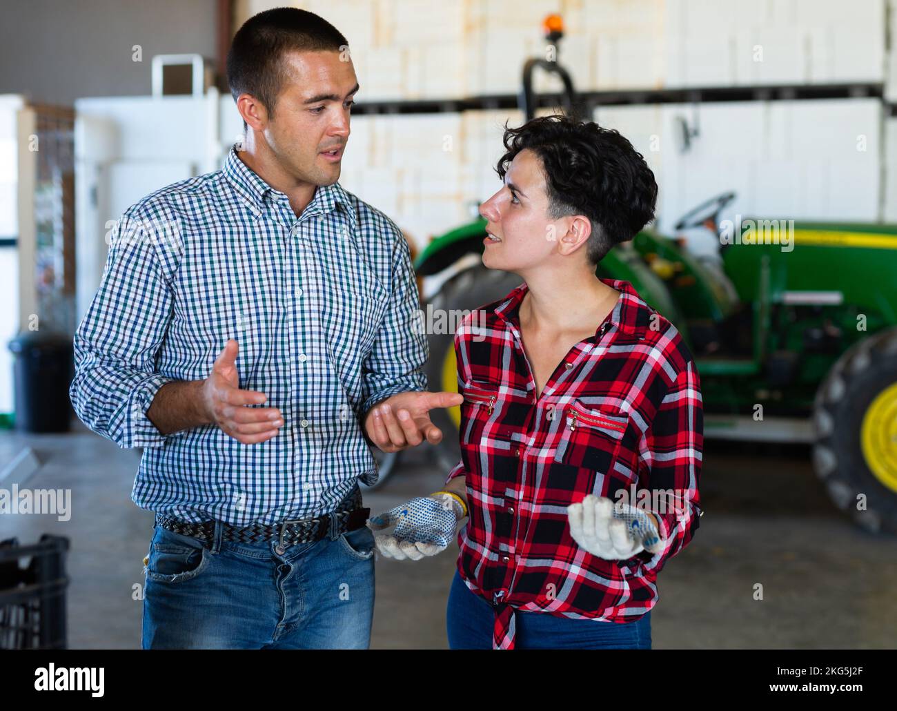 Bauern und Bauern sprechen neben dem Traktor Stockfoto