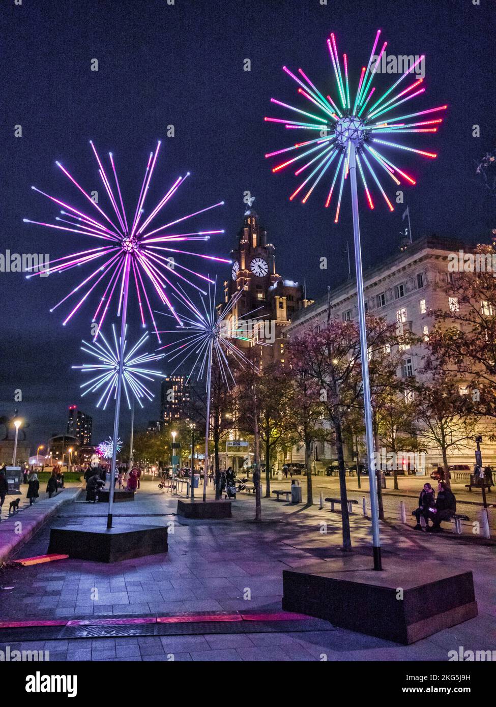 Straßenszenen rund um Pier Head und die Three Graces Gebäude in der Hafenstadt Liverpool, die hier während des River of Light Festivals zu sehen sind Stockfoto