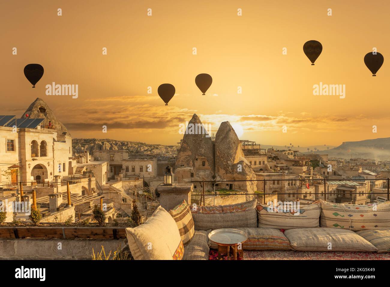 Auf dem Dach der Terrasse fliegen Morgensonnenauf und Ballons fliegen in Kappadokien, Goreme, Türkei. Keine Menschen, warme Töne Stockfoto