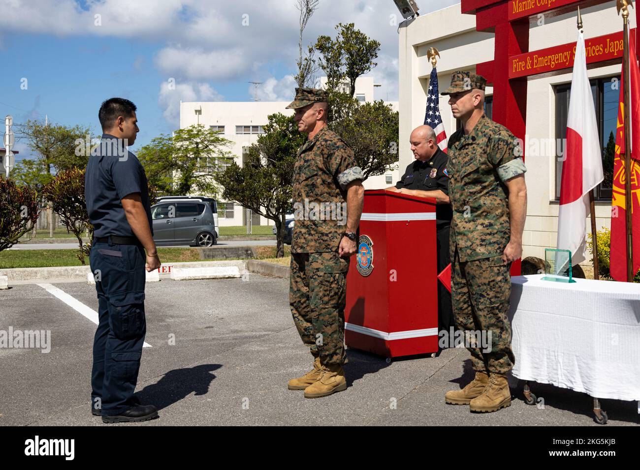 Kaito Kyan, links, ein Feuerwehrmann mit Marine Corps Installationen Pacific Fire and Emergency Services, steht vor dem US Marine Corps Maj. General Stephen E. Liszewski, Center, dem kommandierenden General von MCIPAC, und Sgt. Maj. Anthony J. Easton, rechts, der Sergeant Major von MCIPAC, während der Lesung einer Preiszitation in der Camp Foster Fire Station, Okinawa, Japan, am 5. Oktober 2022. Kyan erhielt den Preis des US Marine Corps Civilian Firefighter of the Year 2021, nachdem er von seinen Kollegen für seine Leistungen, Professionalität, Disziplin und Kernwerte nominiert wurde. Er hat zwei fortgeschrittene Glühwürmchen verdient Stockfoto