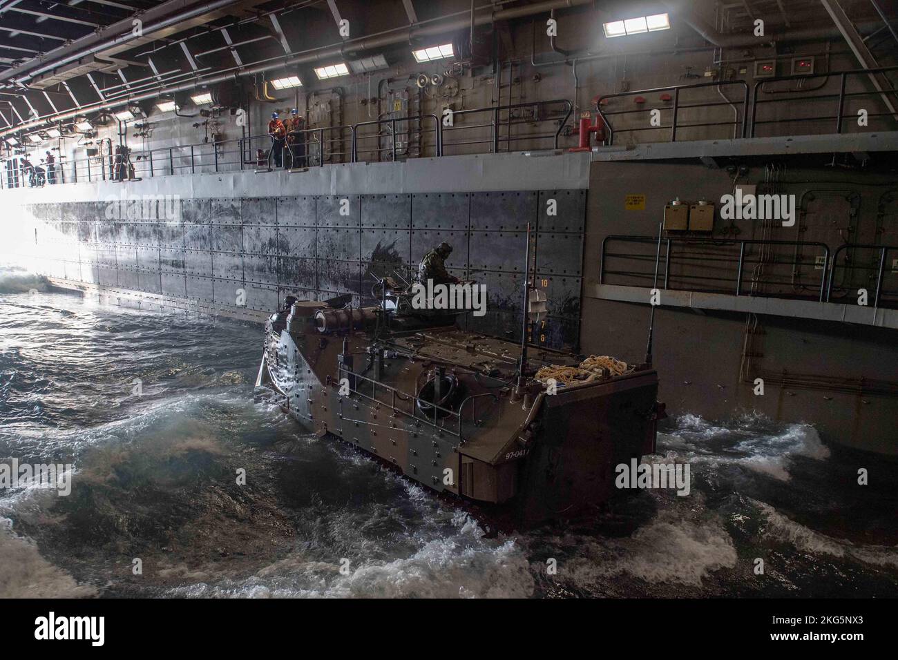 221118-N-XB010-1006 PHILIPPINISCHES MEER (NOV 18, 2022) – Matrosen, die dem im Vorlauf eingesetzten amphibischen Transportschiff USS New Orleans (LPD 18) zugewiesen wurden, stehen im Brunnendeck zur Verfügung, während Mitglieder der Japan Self-Defense Force (JSDF) Amphibious Rapid Deployment Brigade (ARDB) während des Keen Sword 23 in Amphibious Assault Vehicles (AAVs) vom philippinischen Meer zurückkehren. Keen Sword ist eine gemeinsame, bilaterale, alle zwei Jahre stattfindende Übung zum Feldtraining, an der US-Militär und Mitarbeiter der japanischen Selbstverteidigungskräfte beteiligt sind, um die Kampfbereitschaft und Interoperabilität zu erhöhen und das mit Eisen verkleidete Bündnis zwischen Japan und den USA zu stärken. ( Stockfoto