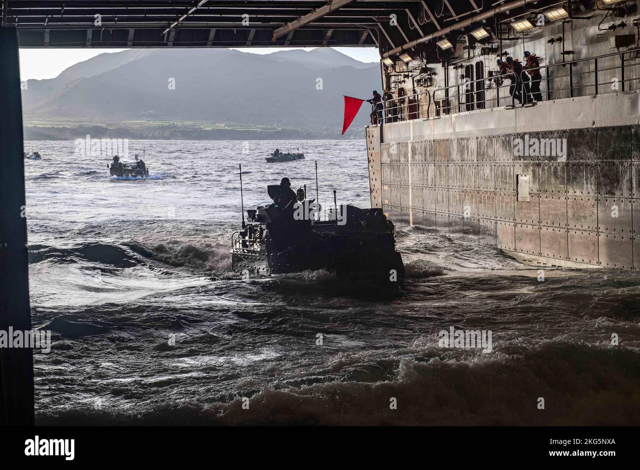 221118-N-XB010-1008 PHILIPPINISCHES MEER (NOV 18, 2022) – Matrosen, die dem im Vorlauf eingesetzten amphibischen Transportschiff USS New Orleans (LPD 18) zugewiesen wurden, stehen im Brunnendeck zur Verfügung, während Mitglieder der Japan Self-Defense Force (JSDF) Amphibious Rapid Deployment Brigade (ARDB) während des Keen Sword 23 in Amphibious Assault Vehicles (AAVs) vom philippinischen Meer zurückkehren. Keen Sword ist eine gemeinsame, bilaterale, alle zwei Jahre stattfindende Übung zum Feldtraining, an der US-Militär und Mitarbeiter der japanischen Selbstverteidigungskräfte beteiligt sind, um die Kampfbereitschaft und Interoperabilität zu erhöhen und das mit Eisen verkleidete Bündnis zwischen Japan und den USA zu stärken. ( Stockfoto