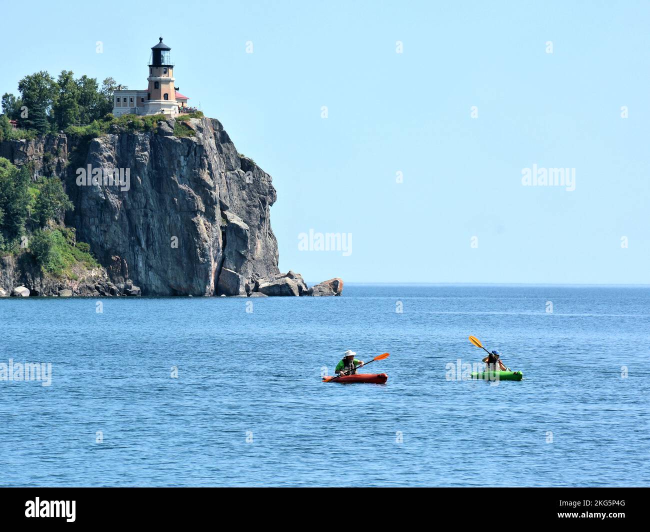 Zwei Kajakfahrer paddeln auf dem Lake Superior mit dem berühmten Split Rock Lighthouse im Hintergrund Stockfoto