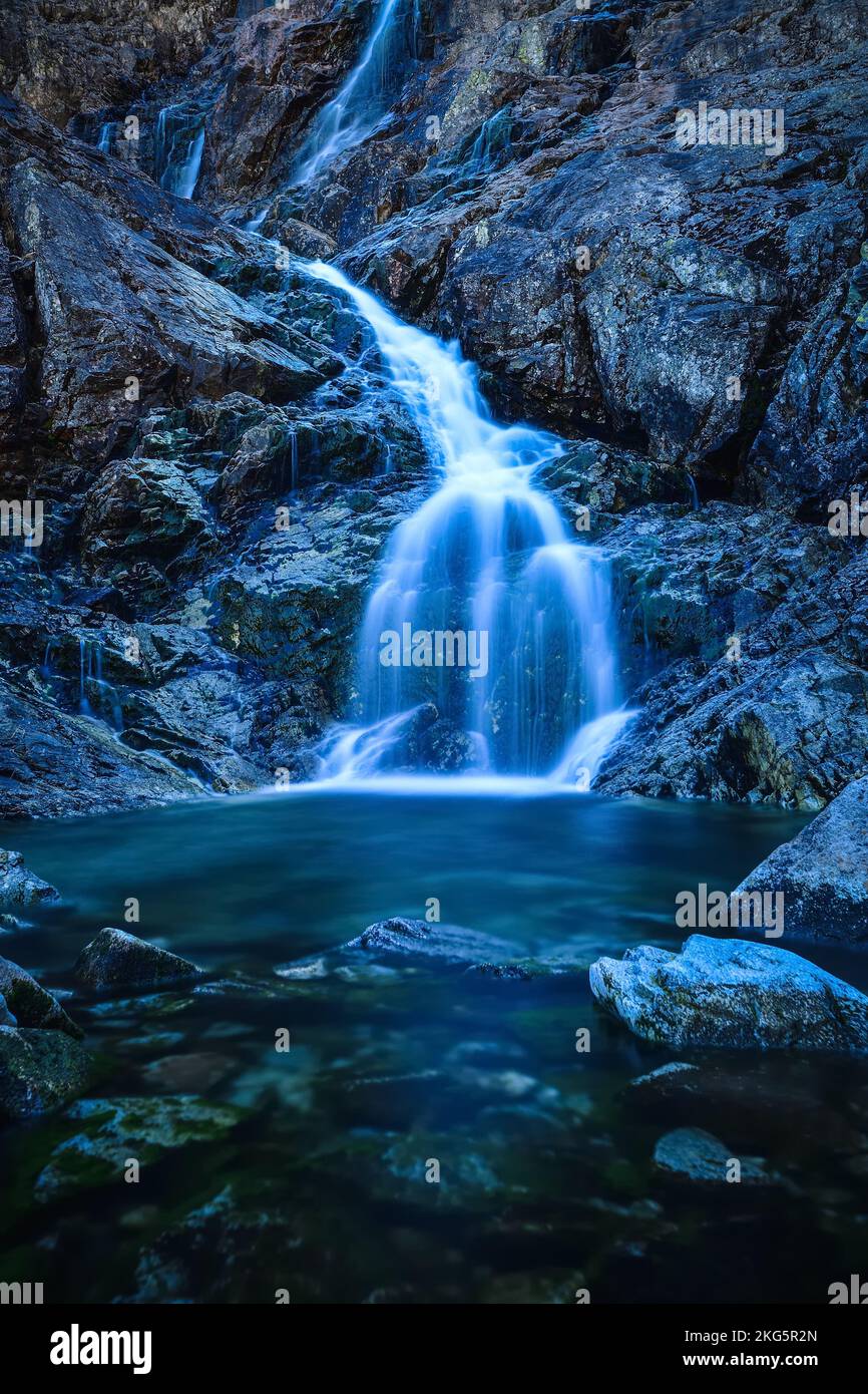 Schöner Wasserfall mit verschwommenem Wassereffekt. Foto im Tal der fünf Teiche in der polnischen Tatra. Foto mit langer Belichtung. Stockfoto