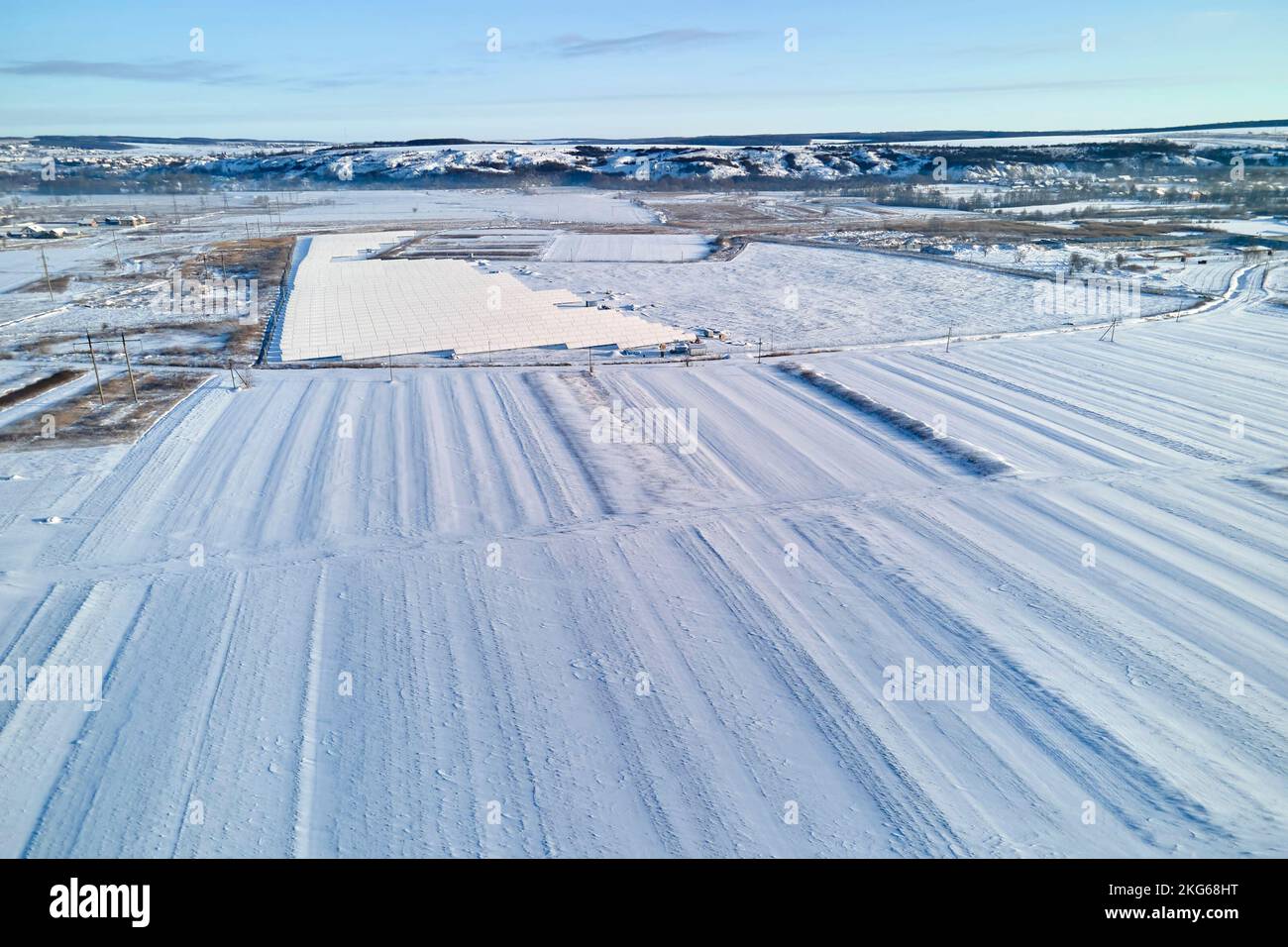 Luftaufnahme von schneebedeckten landwirtschaftlichen Feldern mit karger Oberfläche im Winter Stockfoto