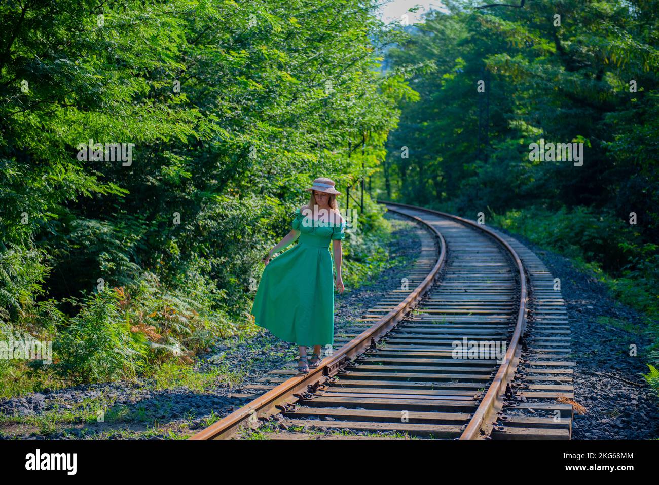 Ein Mädchen in einem grünen Kleid läuft auf der Bahn Stockfoto