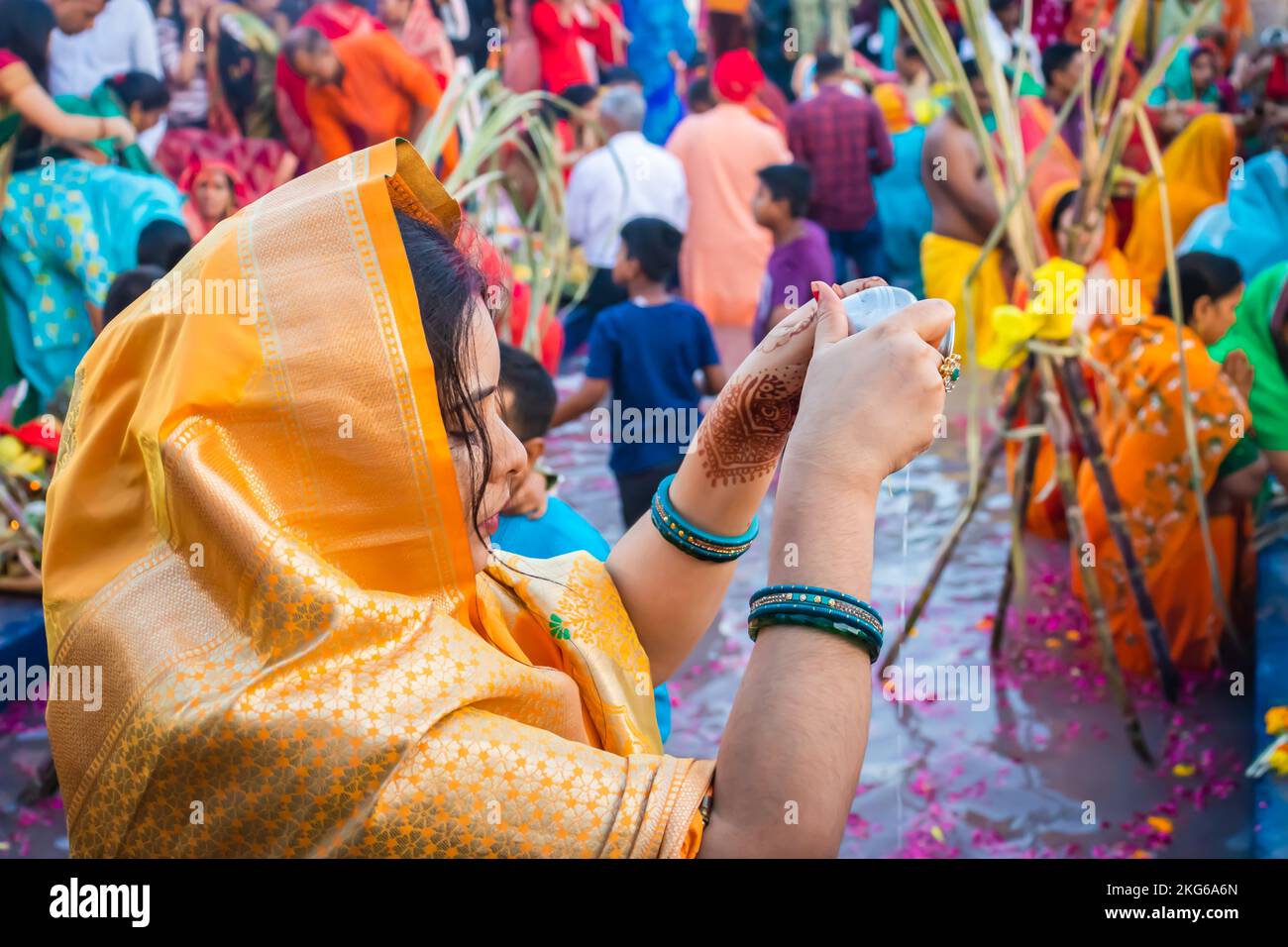 Junge Frauen beten mit religiösen Opfern für den sonnengott in Chhath Stockfoto