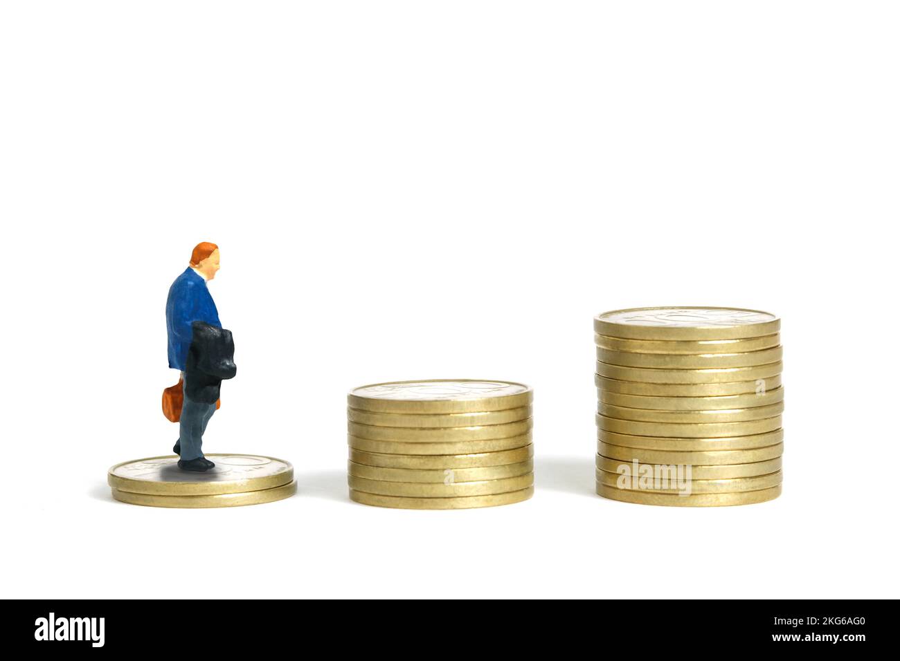 Miniatur-Menschen-Spielzeug-Figuren-Fotografie. Ein Geschäftsmann geht die Treppe hoch, die aus einem Münzhaufen besteht. Isoliert auf weißem Hintergrund. Bildfoto Stockfoto