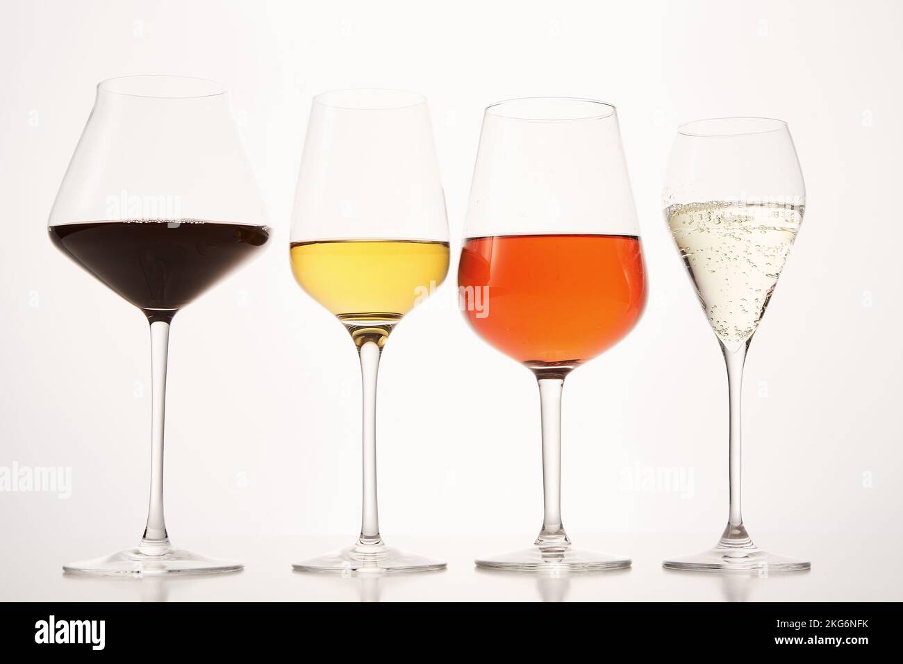 Rosafarbene, weiße, rote, prickelnde alkoholische Getränke in Weingläsern. Stockfoto