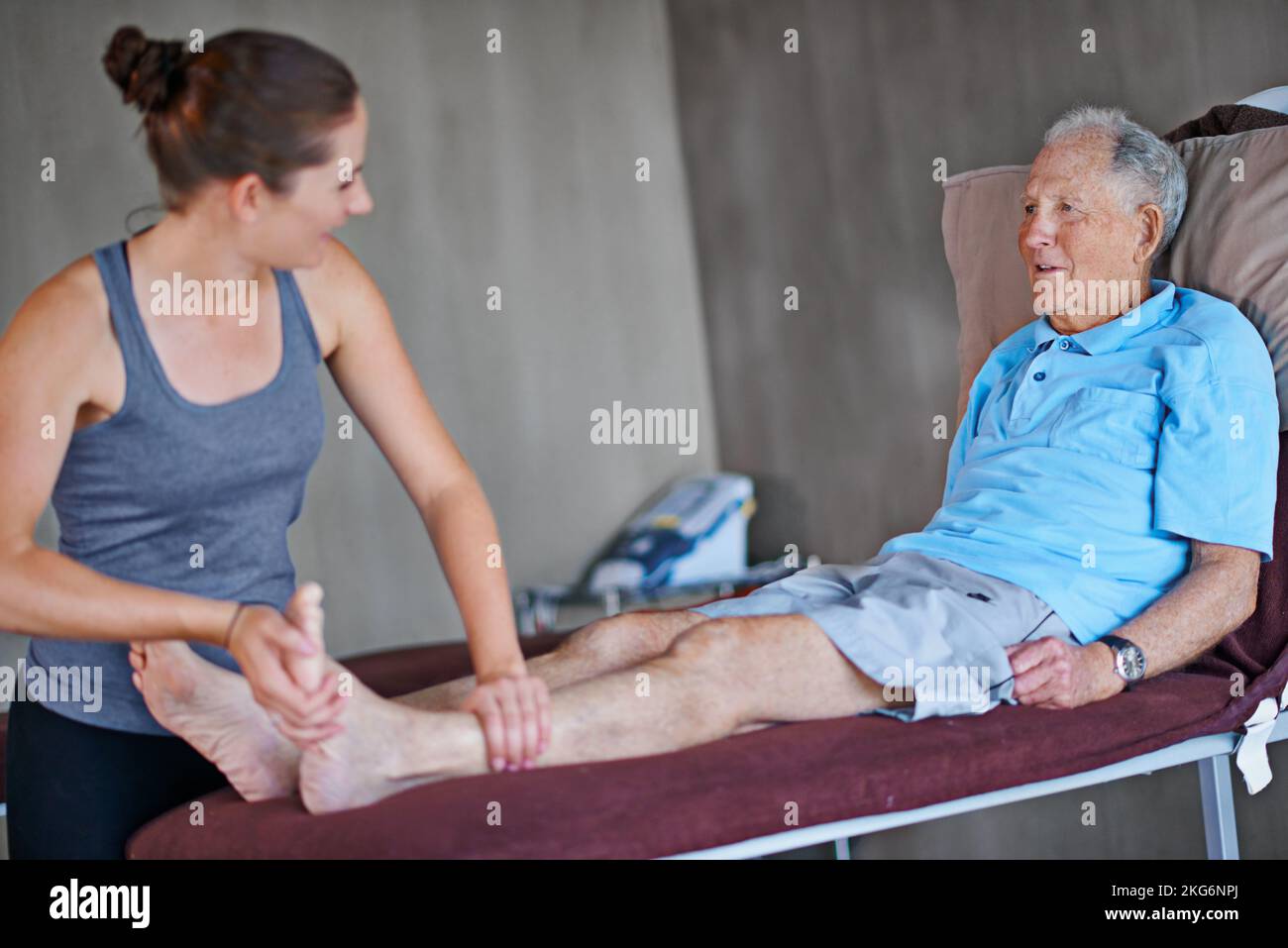 Es fühlt sich viel besser an. Ein älterer Mann, der eine Physiotherapie mit einer Therapeutin hat. Stockfoto