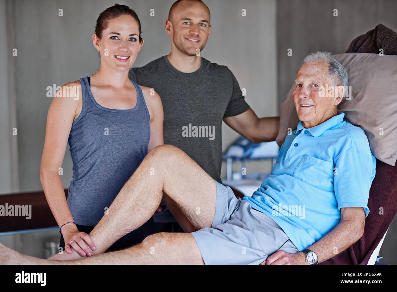Die Genesung unserer Patienten ist das einzige Ziel. Porträt eines älteren Mannes und zweier Physiotherapeuten. Stockfoto