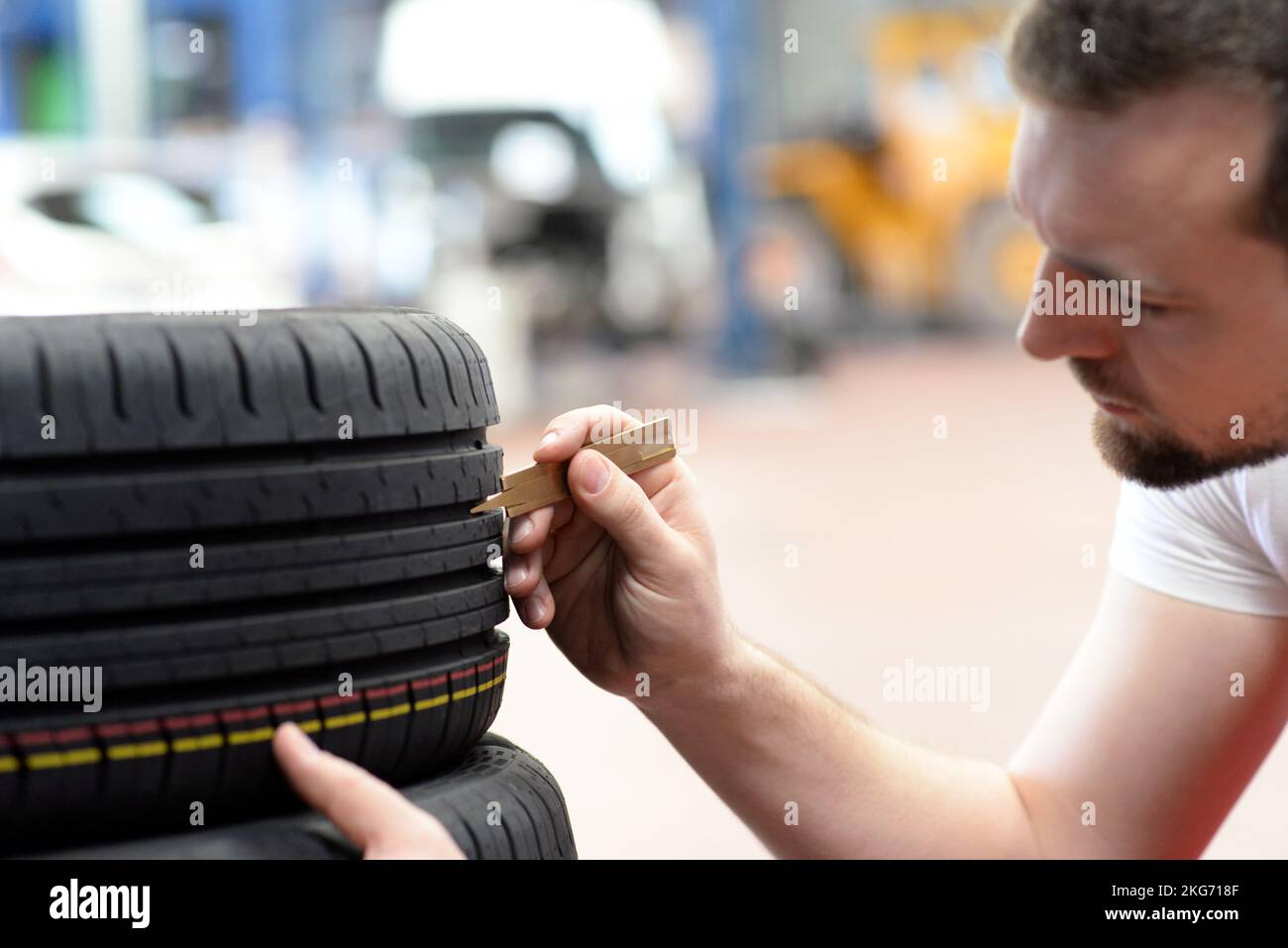Mechaniker steuert die Profiltiefe der Reifen Stockfoto