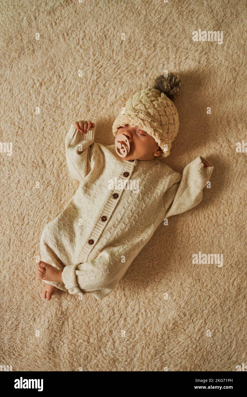 Schlafendes Neugeborenes in einem Wollrumpf Stockfoto