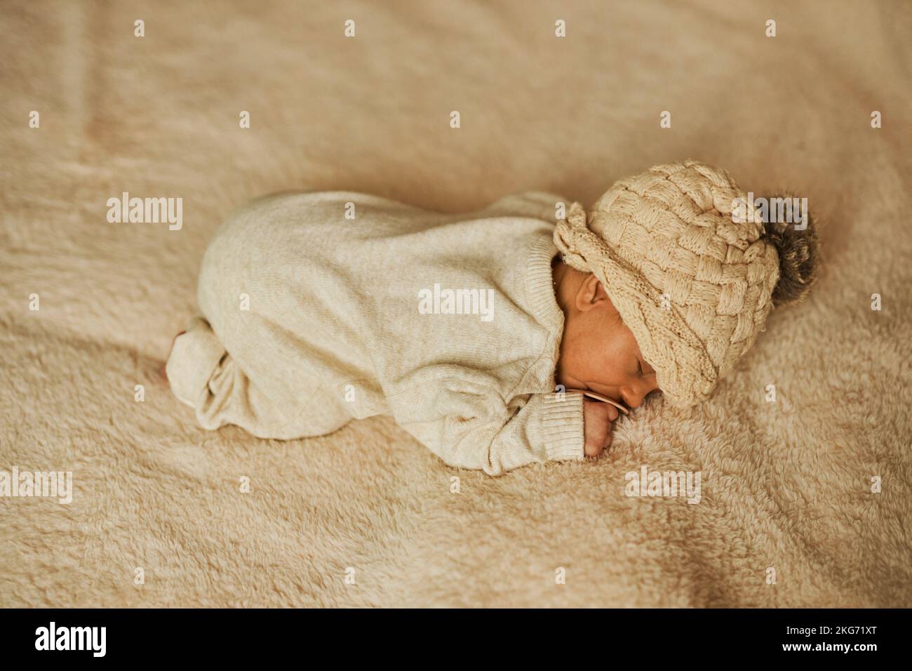 Schlafendes Neugeborenes in einem Wollrumpf Stockfoto