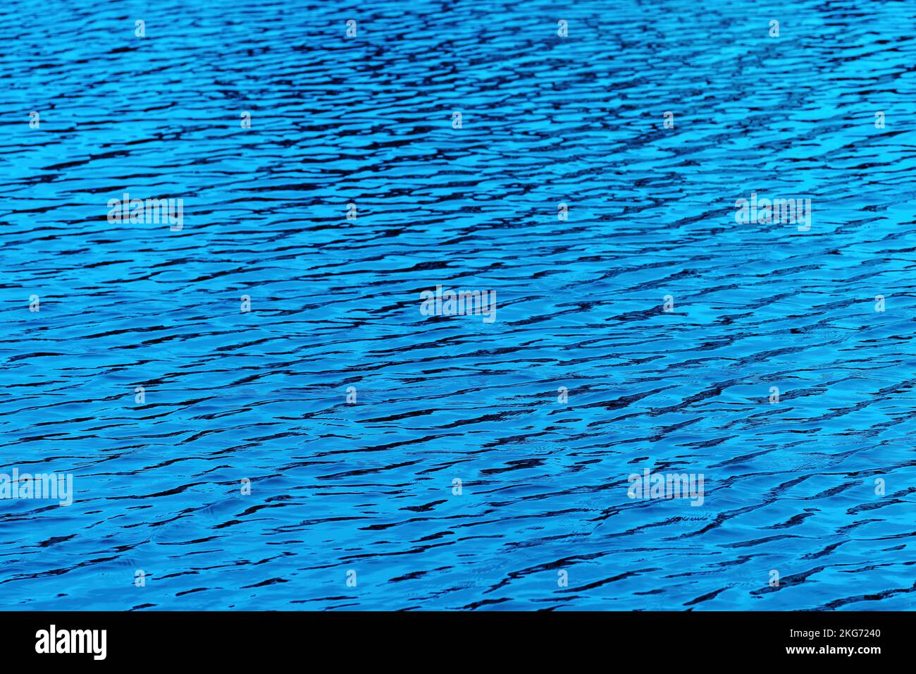 Blaue Wasseroberfläche mit Wellen und Lichtreflexion. Textur des sauberen Süßwassers des Nissan-Flusses in der Stadt Halmstad in Schweden. Selektiver Fokus Stockfoto