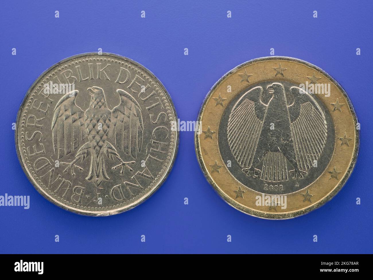 Eine Deutsche Mark und ein Euro auf einem Hintergrund. Alte Münzen, deutsche Münzen. Sammlung von Münzen. Stockfoto