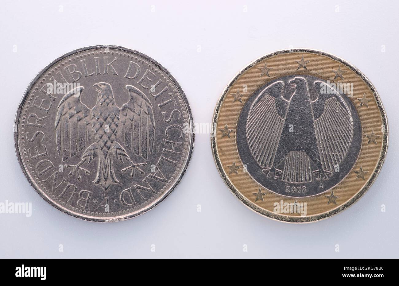 Eine Deutsche Mark und ein Euro auf einem Hintergrund. Alte Münzen, deutsche Münzen. Sammlung von Münzen. Stockfoto