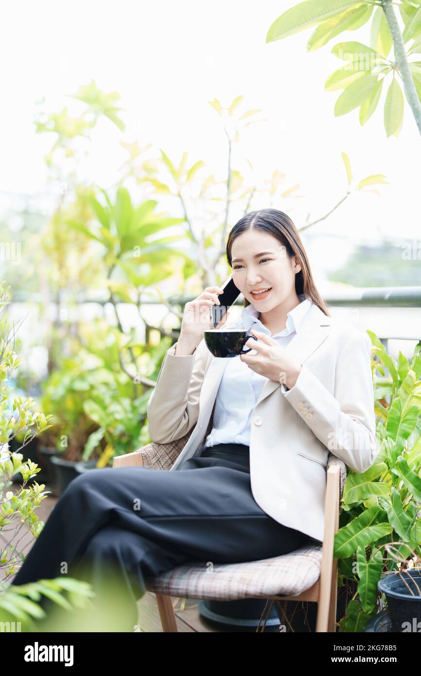 Porträt einer Geschäftsfrau, die am Telefon spricht und Kaffee trinkt Stockfoto