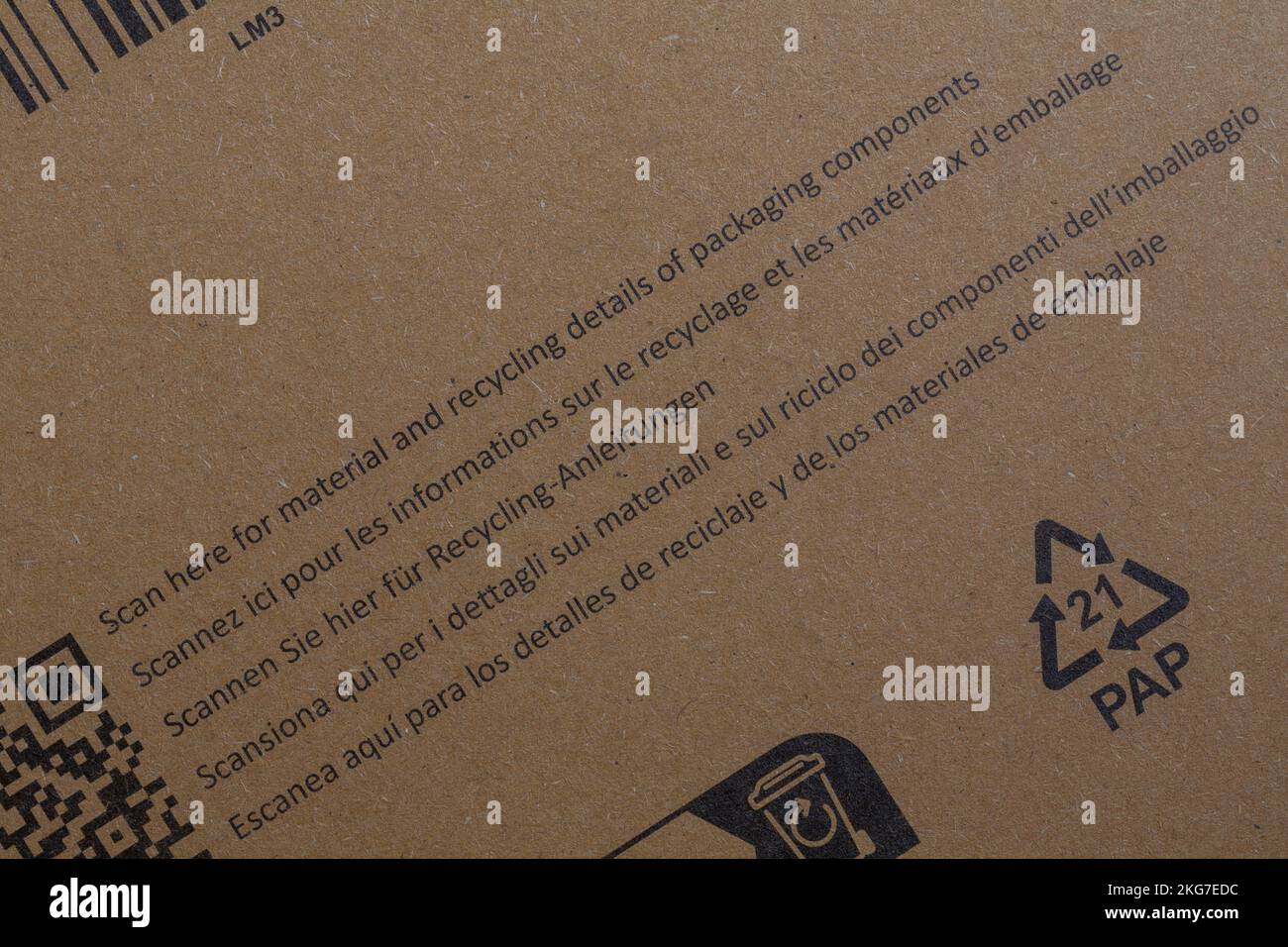 Scannen Sie hier nach Material- und Recyclingdetails von Verpackungskomponenten in verschiedenen Sprachen auf braunen Verpackungen von Amazon Stockfoto