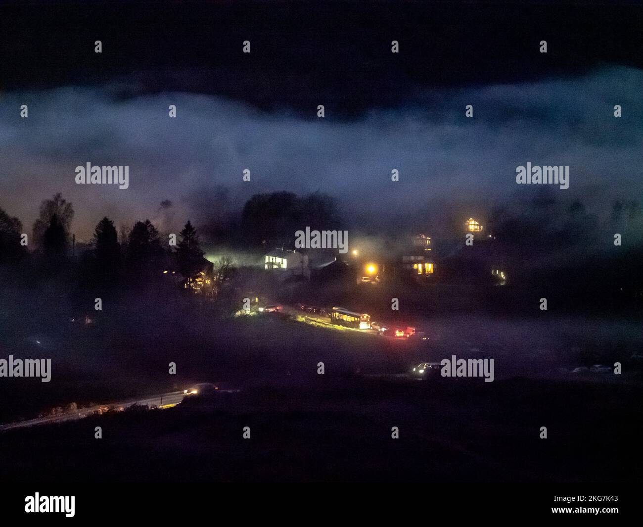 Nebel über Elterwater Dorf im Langdale Valley, Lake District, Großbritannien mit Menschen auf der Straße zu gehen. Stockfoto