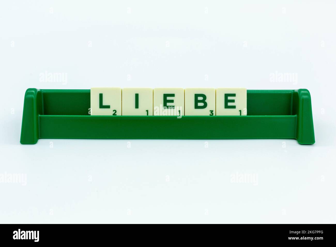 Scrabble-Steine auf dem Brett, "Liebe" auf deutsch geschrieben auf dem Brett Stockfoto