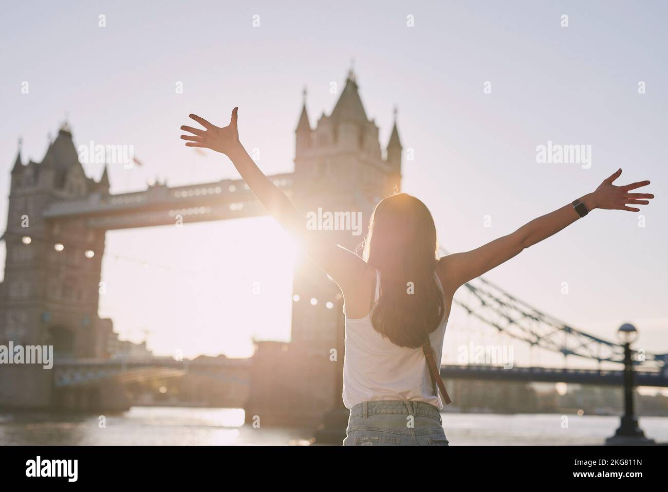 Frau, Freiheit und Reisen Sie an der London Bridge oder der Stadt für einen Urlaub oder einen Sommerurlaub im Freien. Fröhliche weibliche Touristen mit offenen Armen genießen Stockfoto
