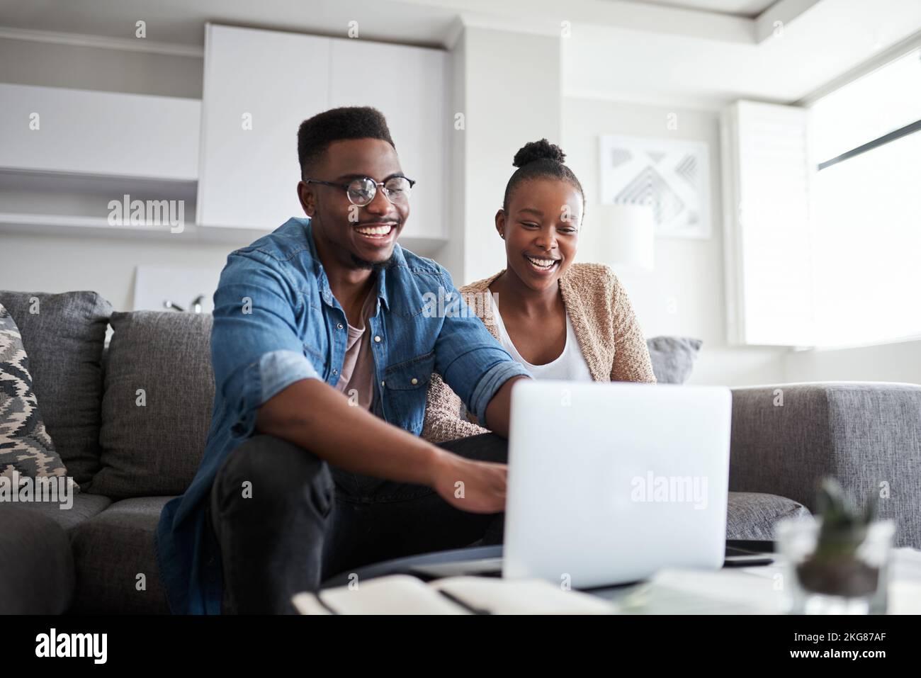 Schwarzes Paar, Laptop und Planung Finanzbudget, Rechnungen und Darlehen mit Netzwerkverbindung oder Home WiFi auf Wohnzimmercouch. Mann und Frau über soziale Medien Stockfoto