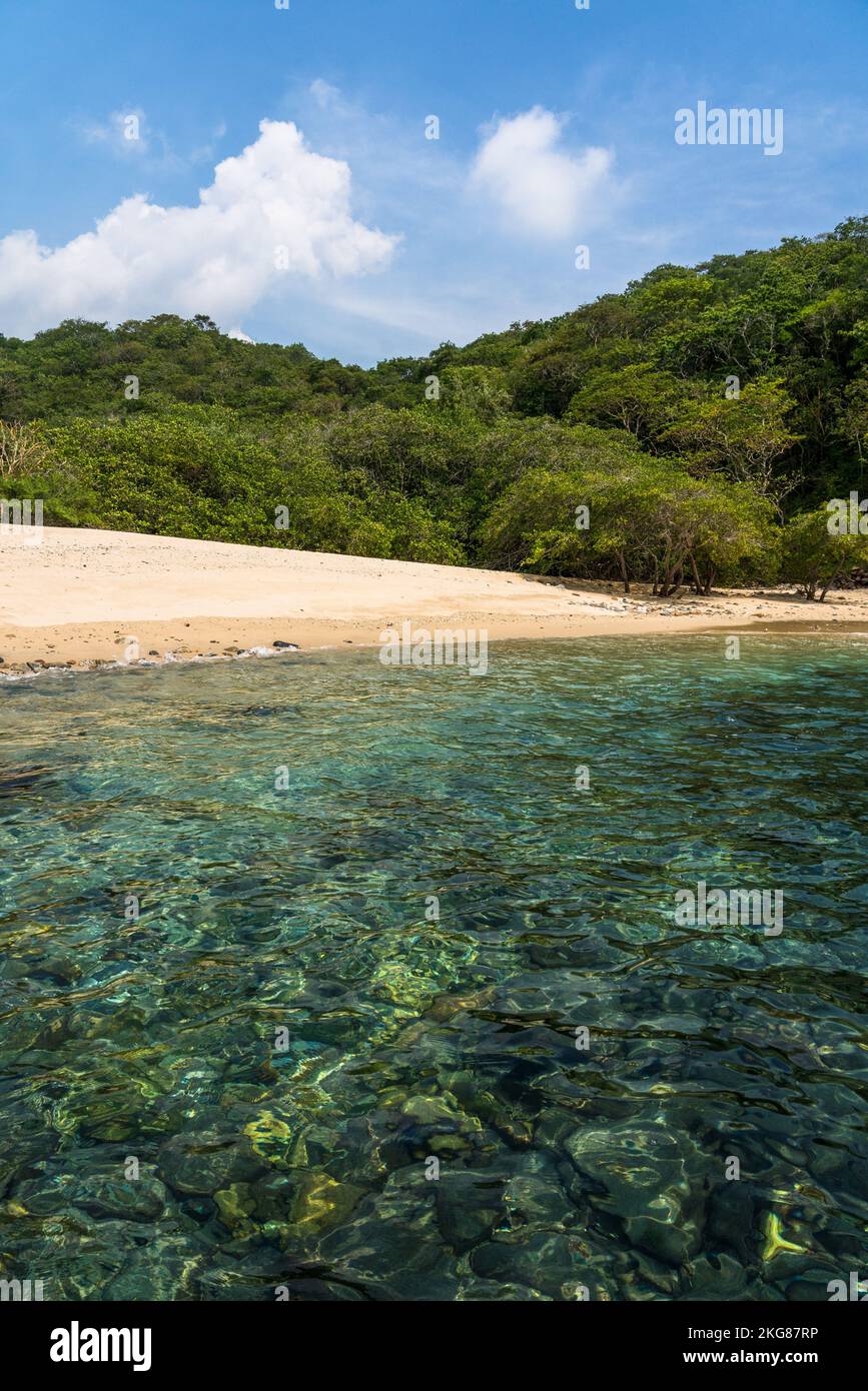Ein kleiner, abgeschiedener Strand mit kristallklarem Wasser, der nur mit dem Boot erreicht werden kann, im Huatulco Nationalpark, Mexiko. Ein UNESCO-Biosphärenreservat. Stockfoto