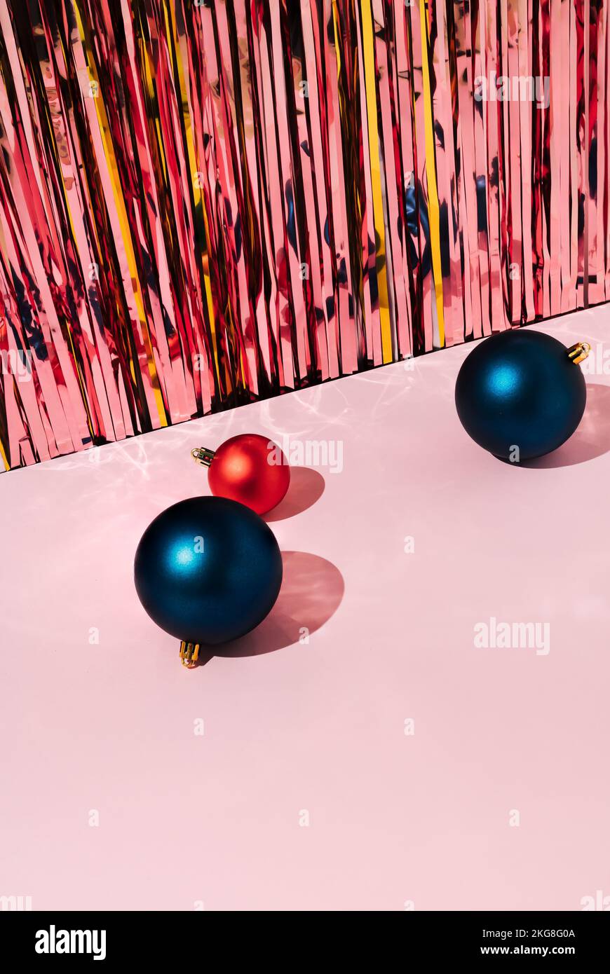 Weihnachtsdekoration Kugeln auf pinkfarbenem Hintergrund mit glänzenden Tinsels. Neujahrsgrüßungskonzept. Stockfoto