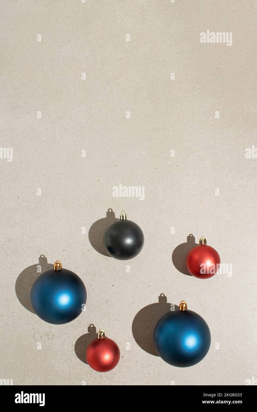 Weihnachtsdekoration mit Kugeln auf grauem Steinhintergrund. Minimales Neujahrskonzept. Stockfoto