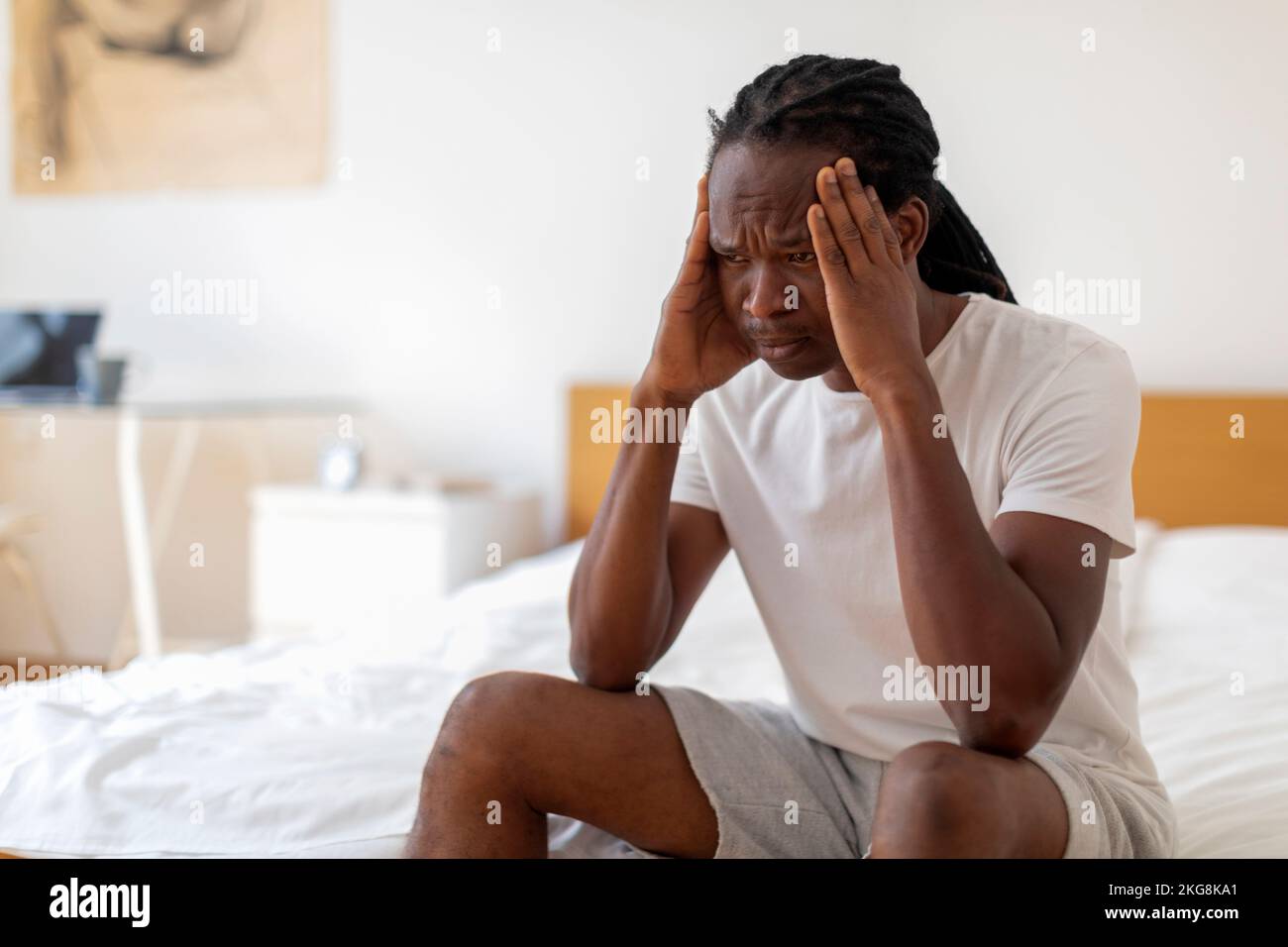 Deprimierter Junger Afroamerikanischer Mann, Der Zu Hause Im Bett Sitzt Stockfoto