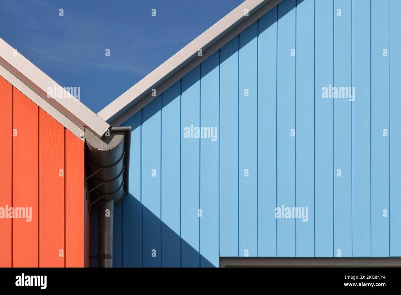 Detailfoto des bemalten Holzes einiger skandinavischer Gebäude in Lauwersoog, Niederlande. Abstraktes geometrisches Bild in Orange und Blau Stockfoto