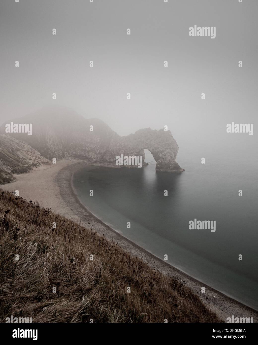 Ein Blick auf Durdle Door an einem nebligen Nachmittag mit schlechter Sicht zeigt, wie der gof am Ort die Aussicht verändert. Stockfoto